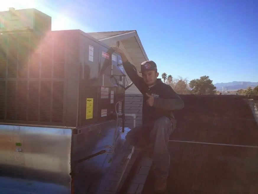HVAC technician performing AC Tune-Up on a rooftop unit in West Haven